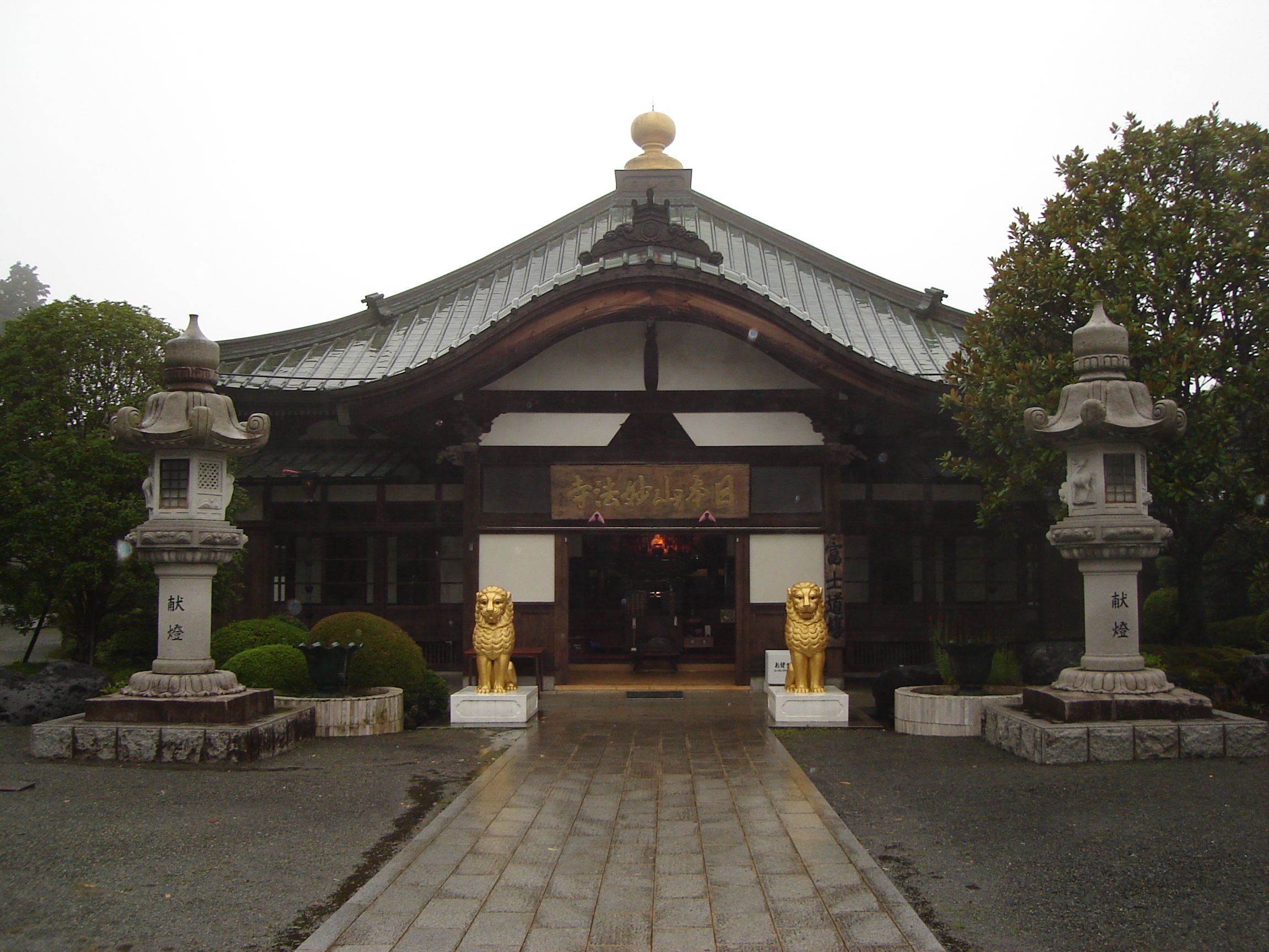 small shrine building with gold lion statues