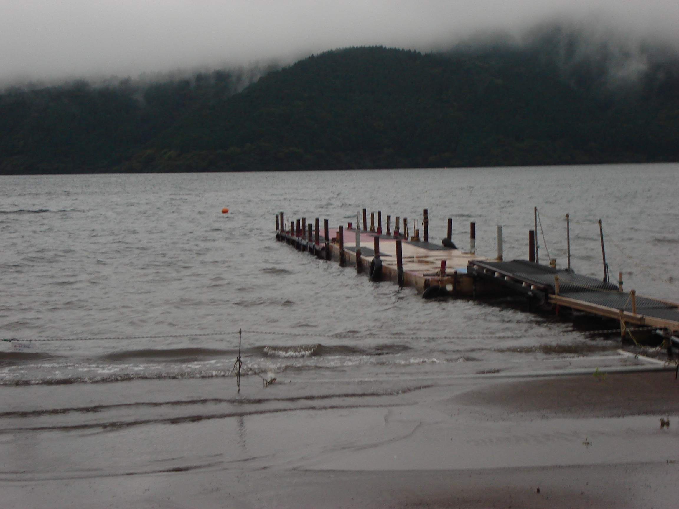 a dock at the shore with the opposite shore visible in the distance