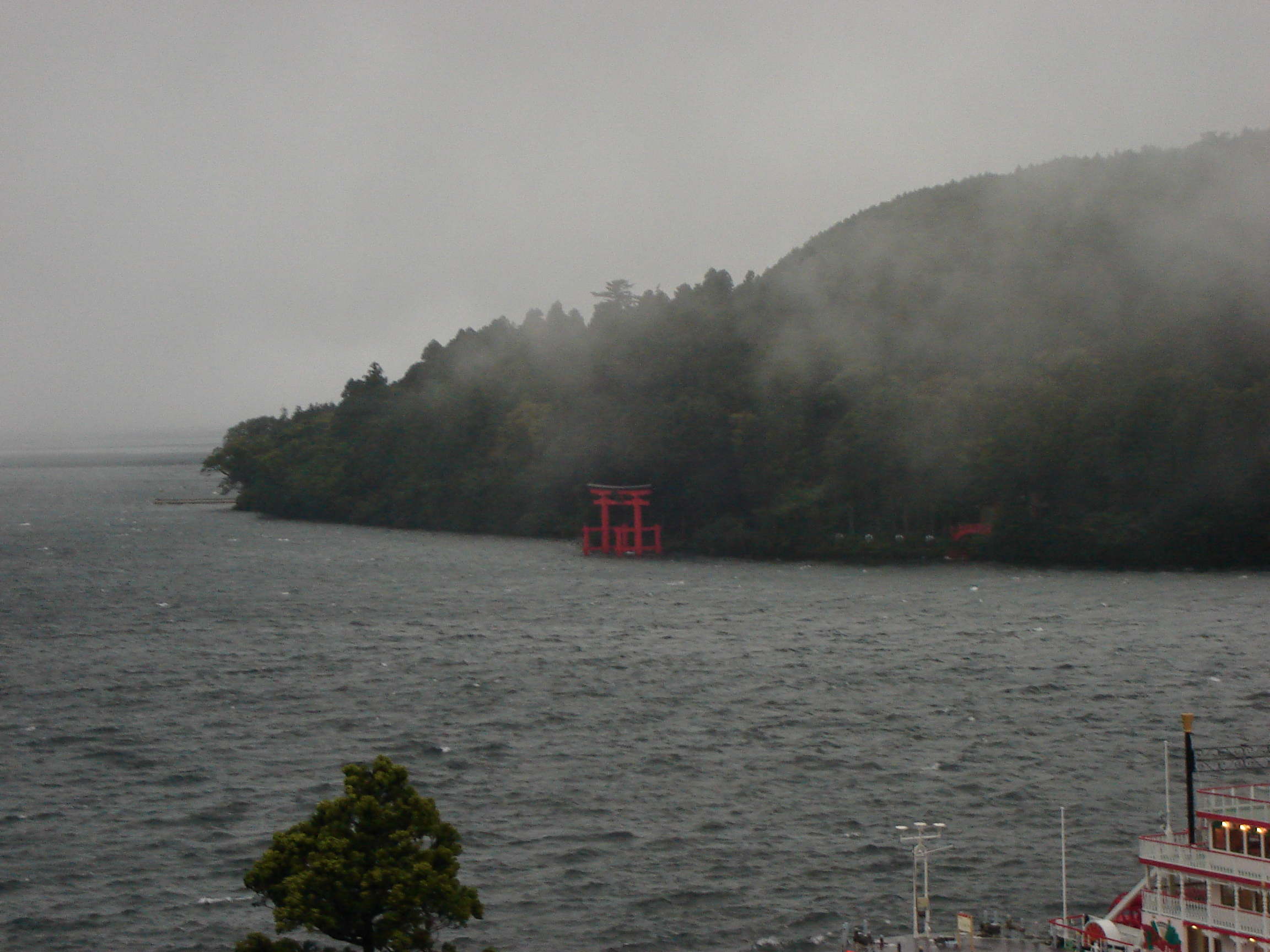 a view across the lake to the opposite shore where a torii gate stands in the water