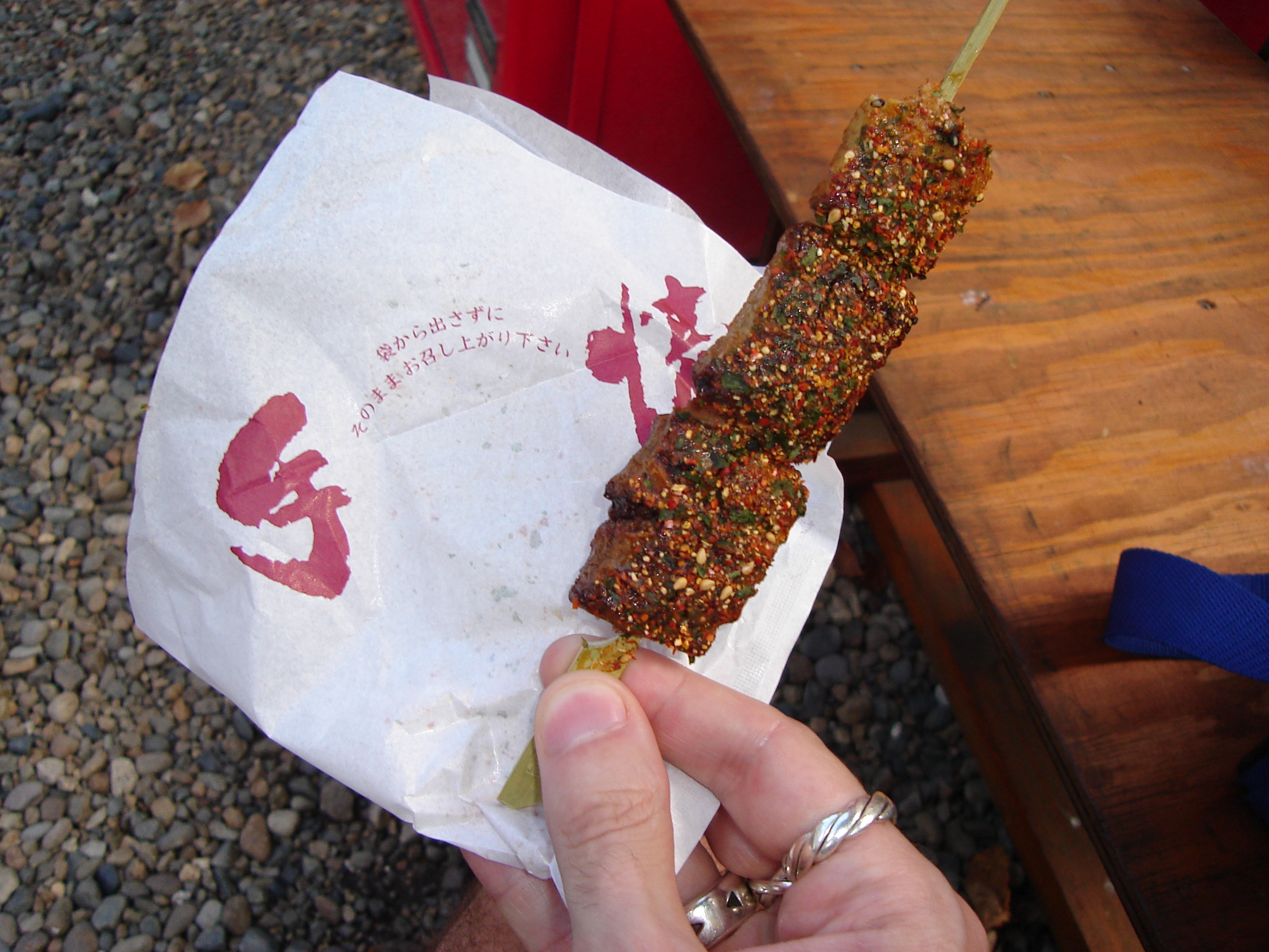 a stick with cubes of rice snack on it with coarse seasonings