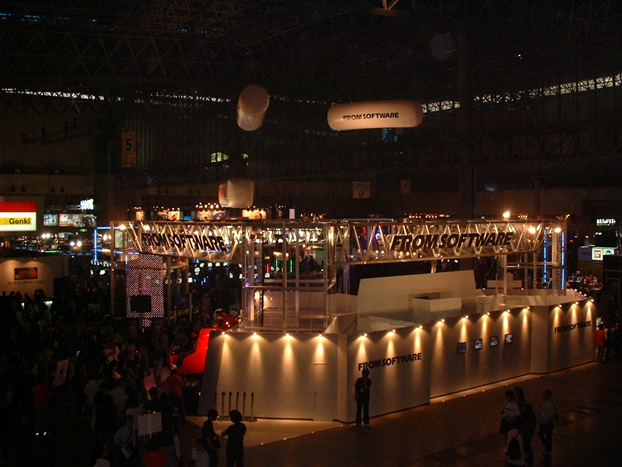 a wide shot of the convention booths with several balloons with logos on them