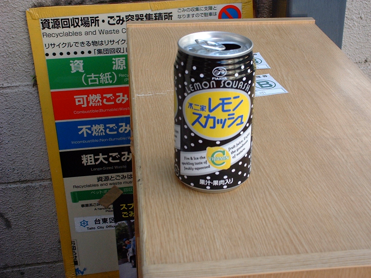 a black soda can with a yellow circle and japanese text
