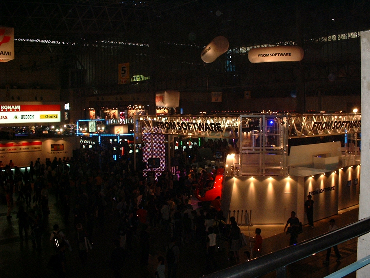 a wide shot of the convention booths with several balloons with logos on them