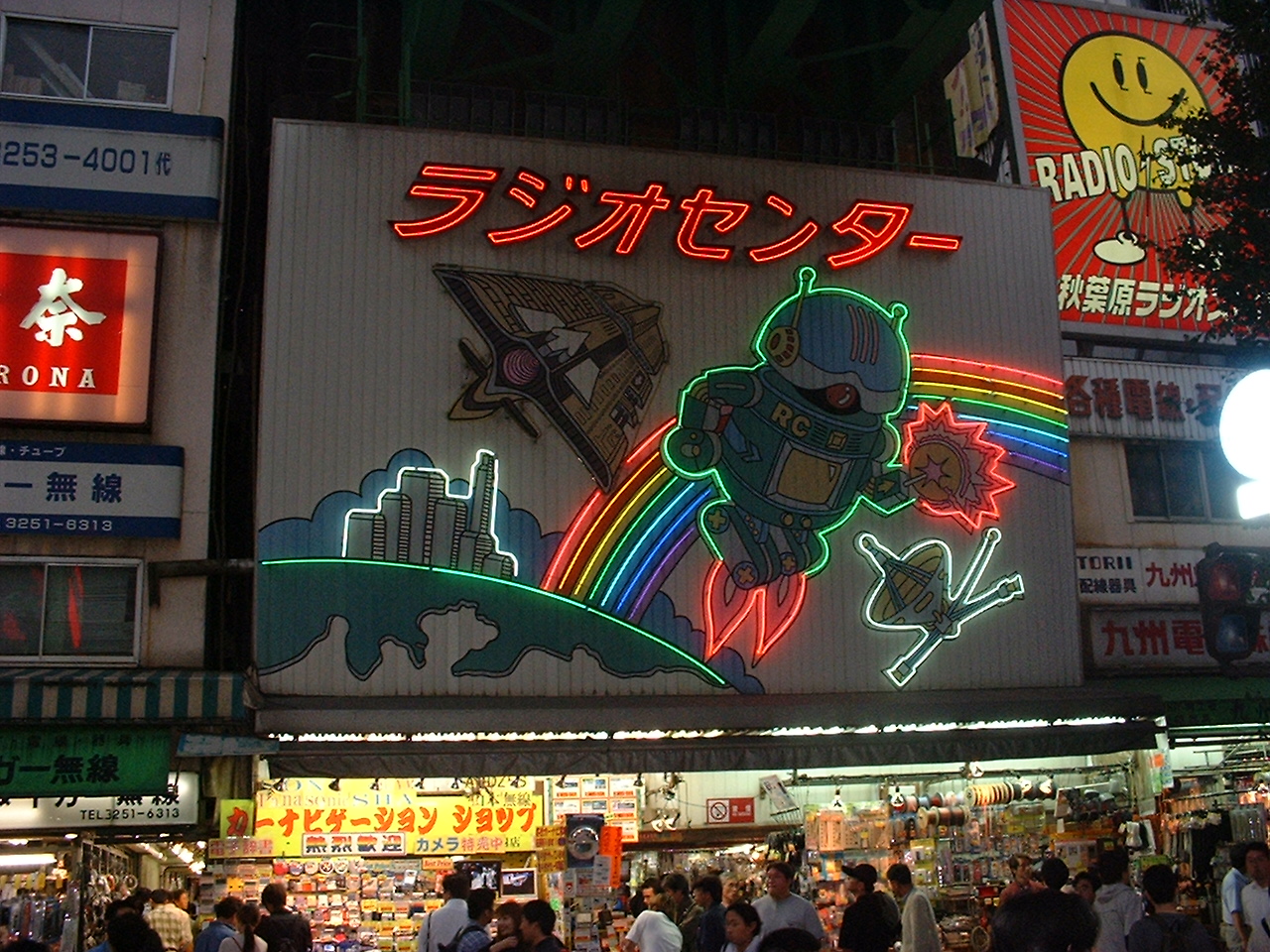 a store with a neon sign showing a robot flying near a rainbow