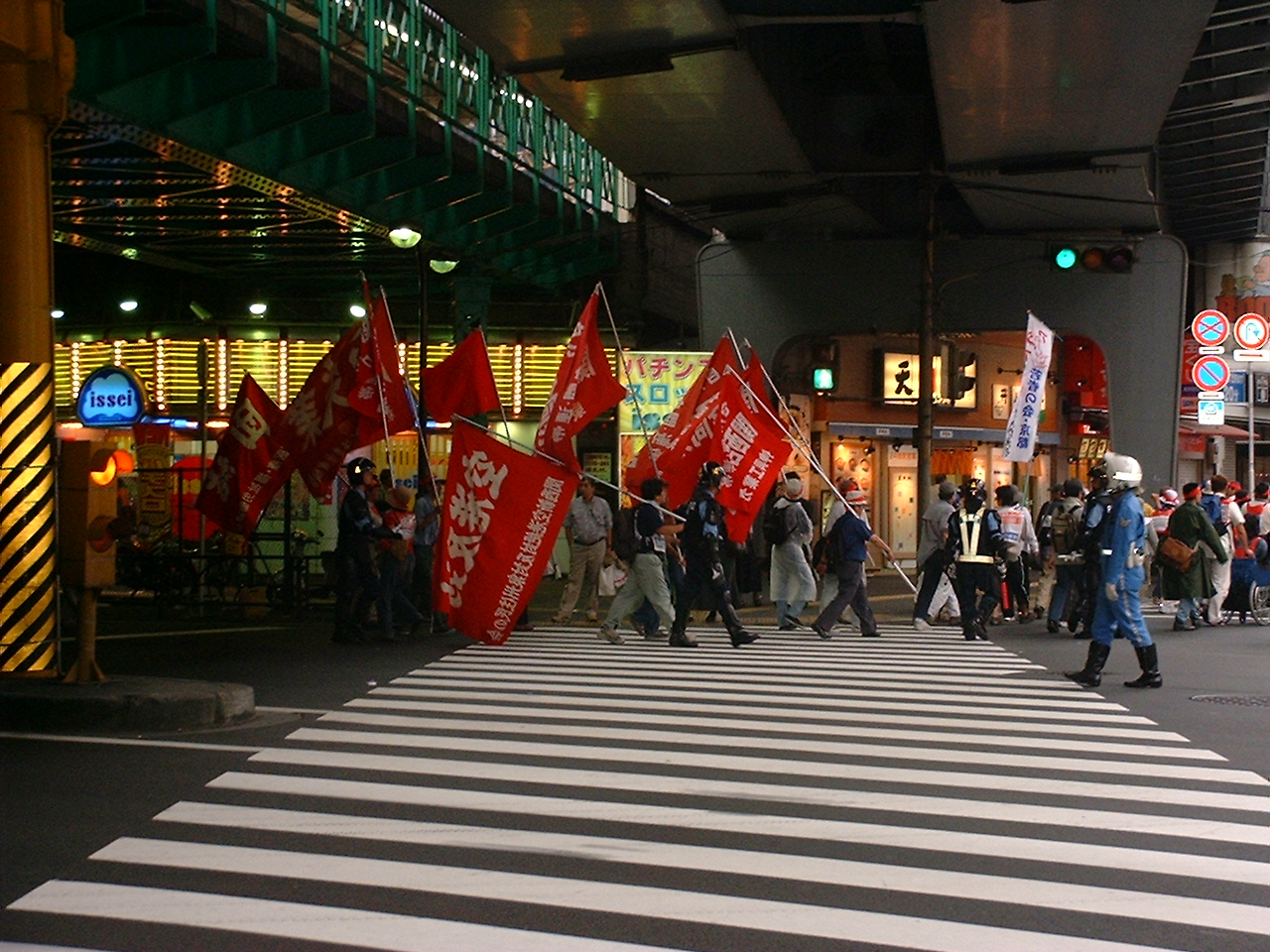 people march with big red flags with white japanese characters