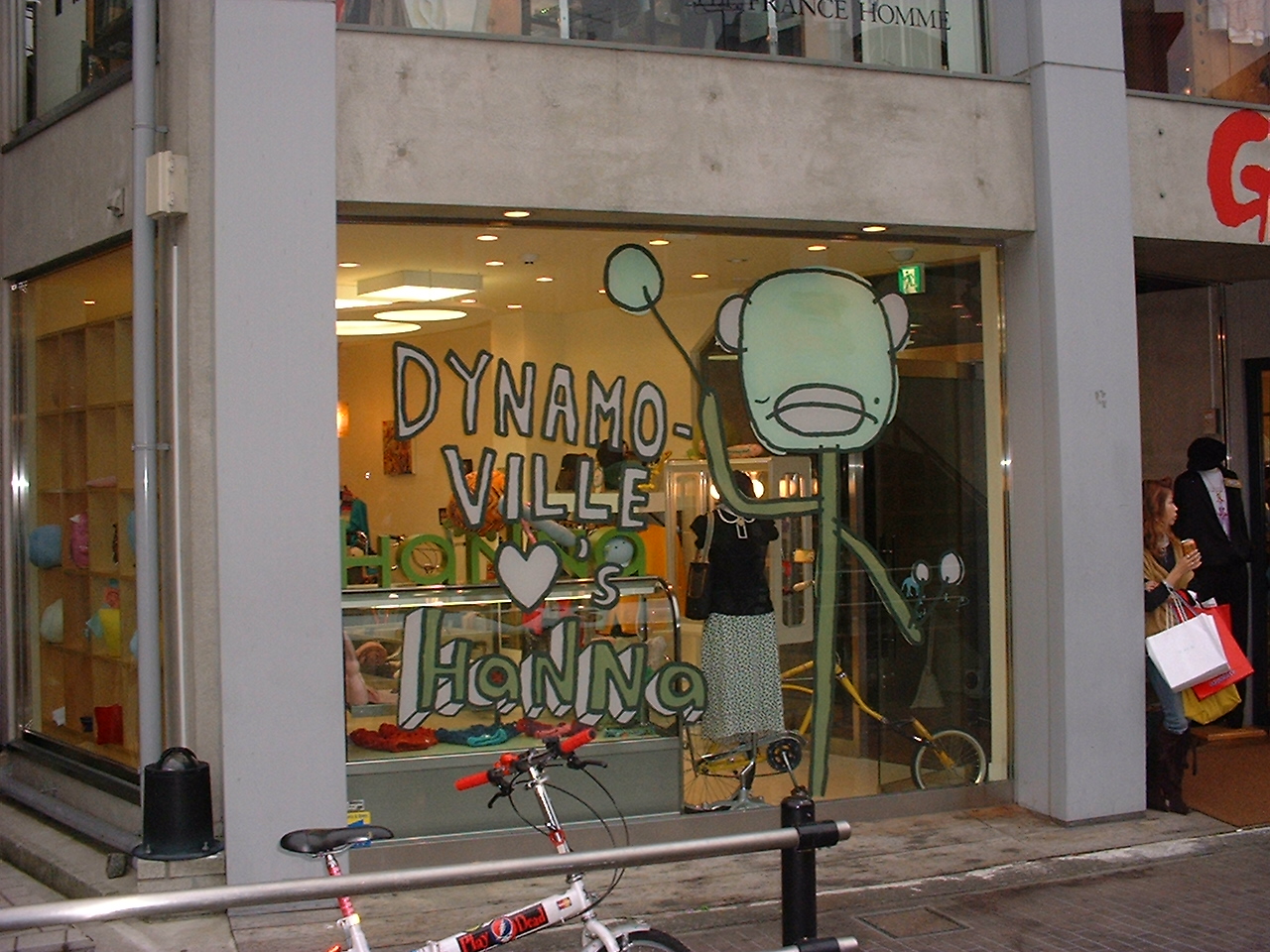 a store with painted text on the window reading dynamo village loves hanna
