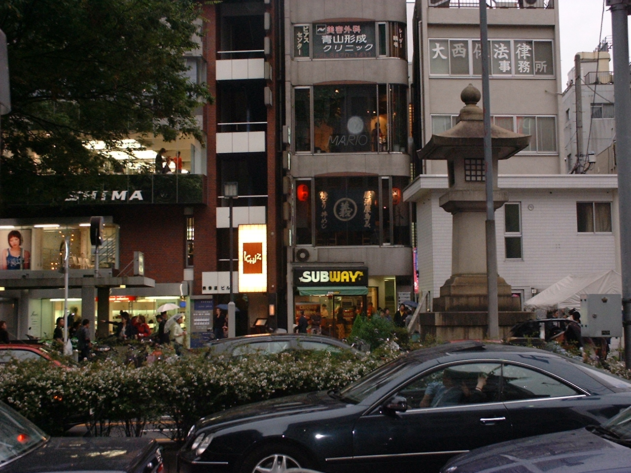 an upscale street with a large traditional stone lantern and a subway sandwich shop