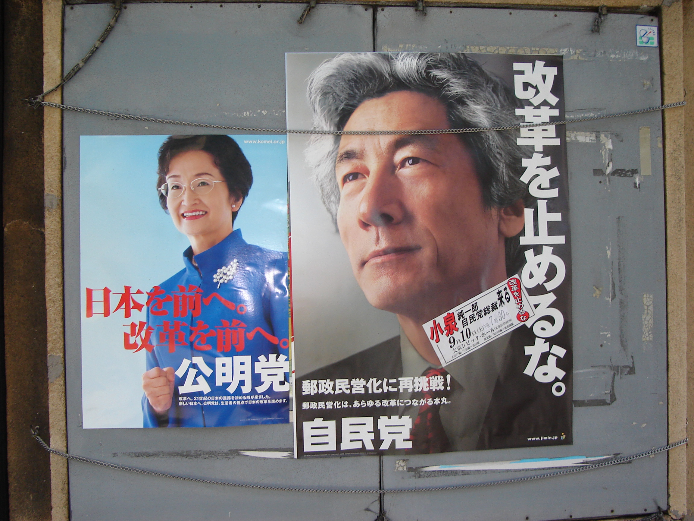 two posters, one of a woman smailing and raising her fist and the second is a closeup of a greying man's face