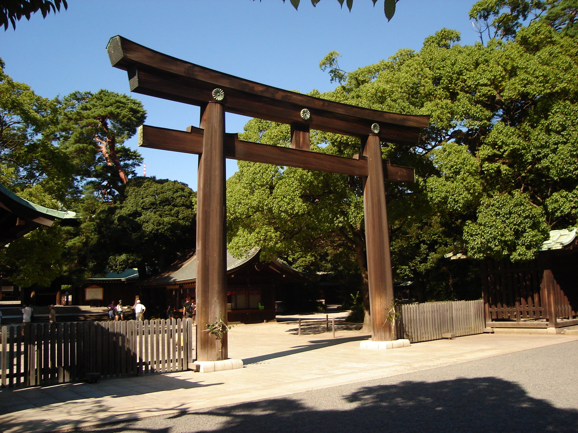 a large wooden torii gate serves as an entrance to a fenced area