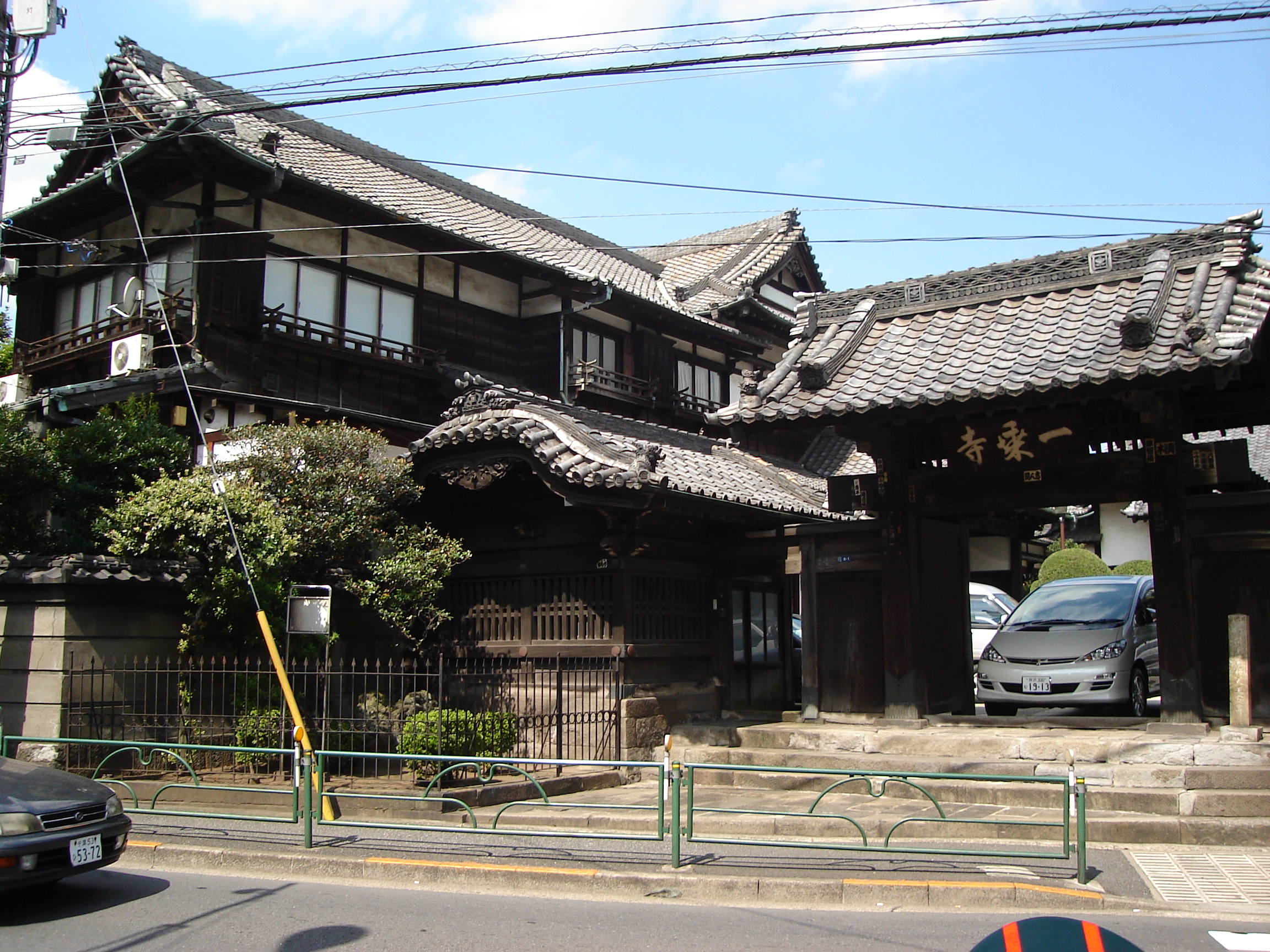 a large traditional house with a car parked under a roof
