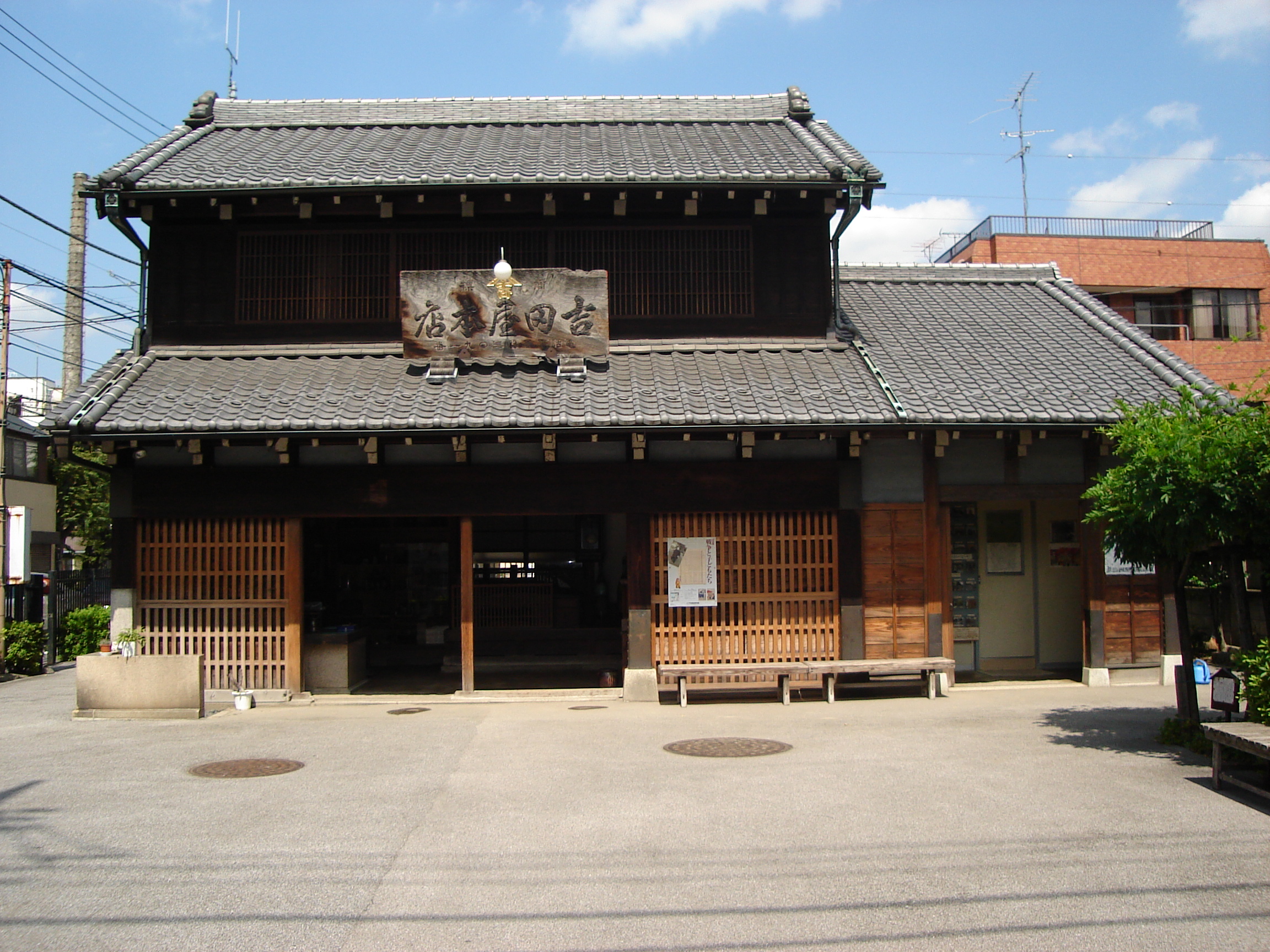 a traditional japanese building with tile roof and wooden screens