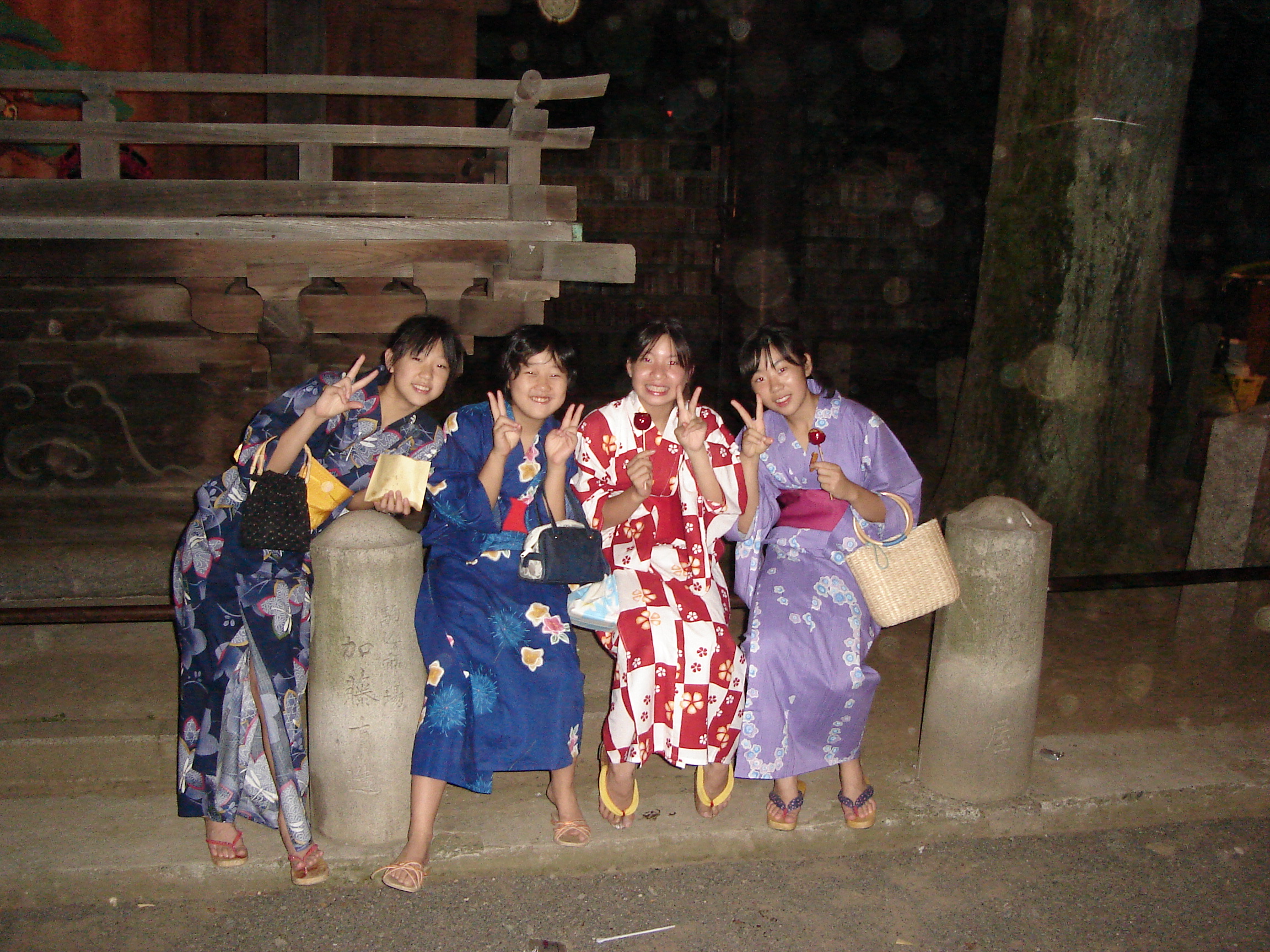 a group of young women in yukata make peace signs