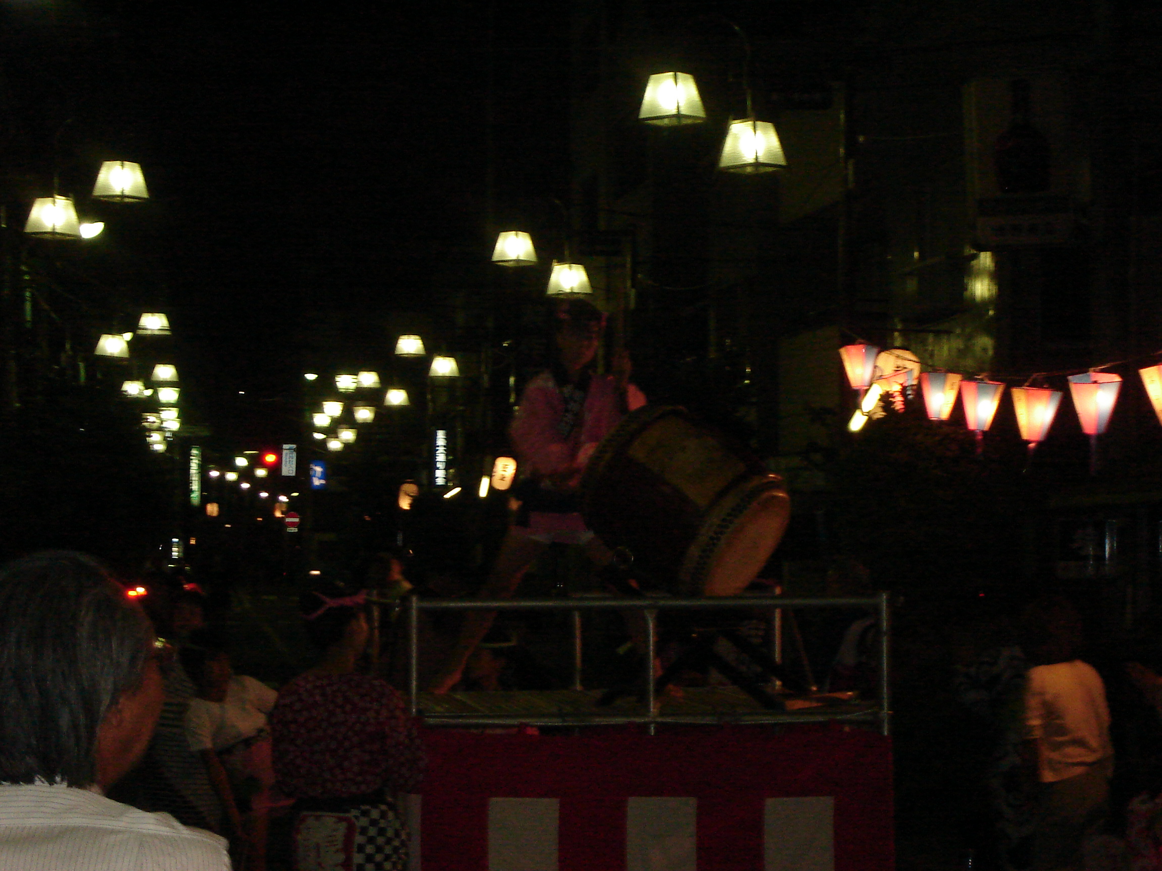 a drummer on a raised platform in the street