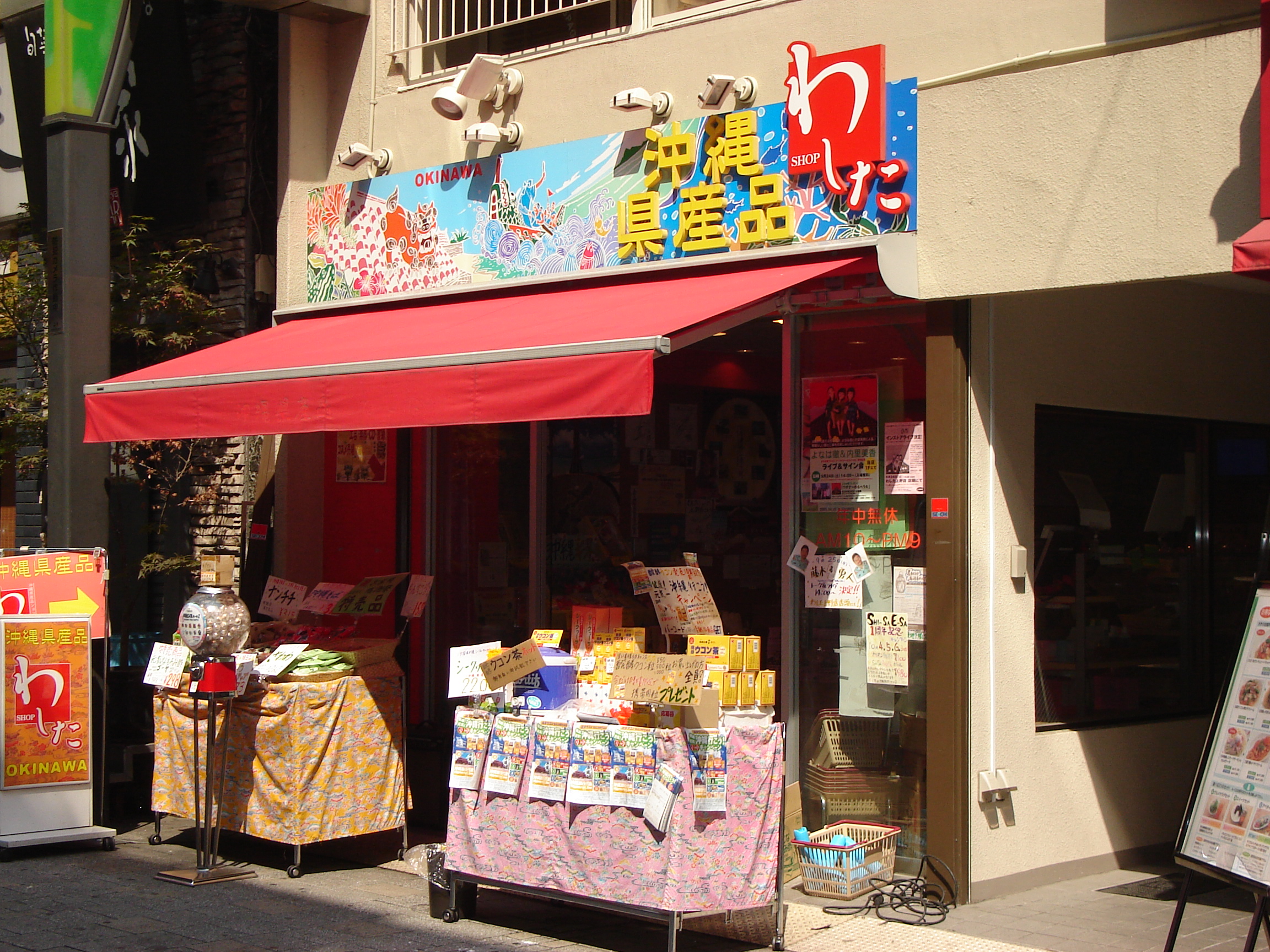 a store with a bright sign and tables of goods out front
