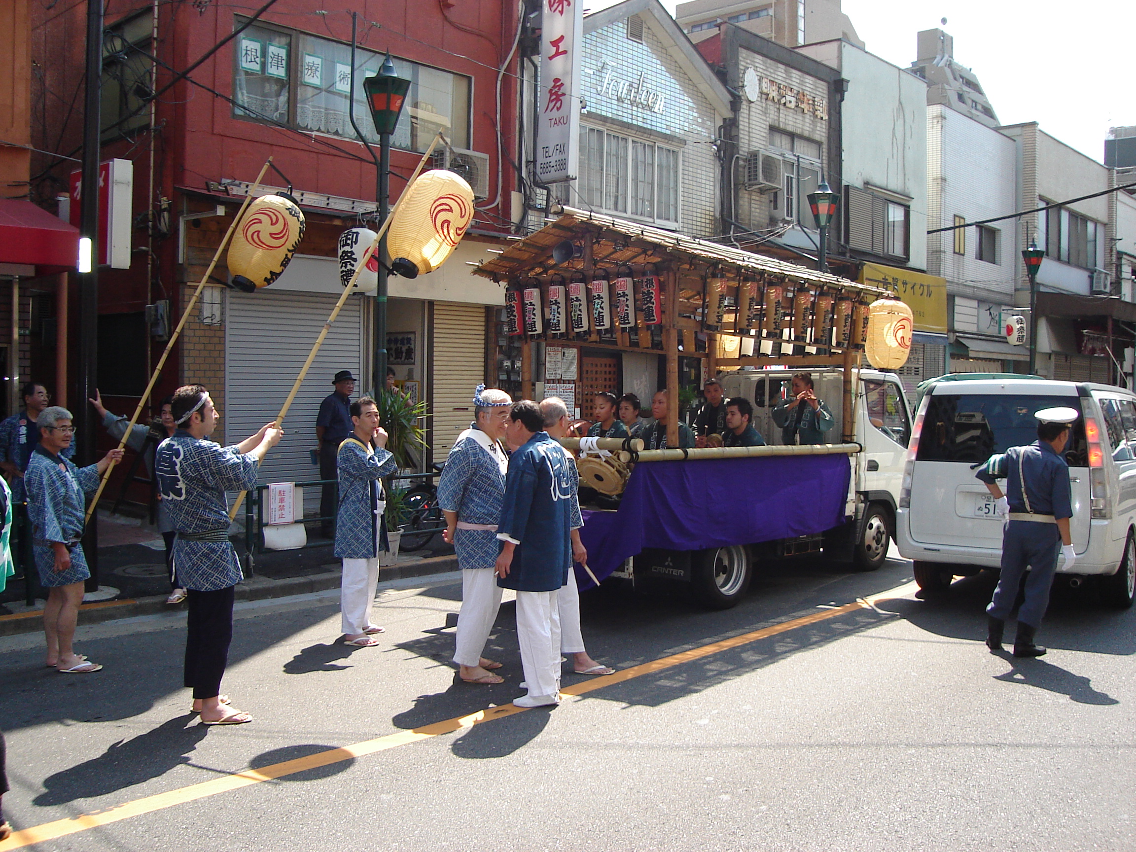 the procession includes a small decorated truck with people in the bed