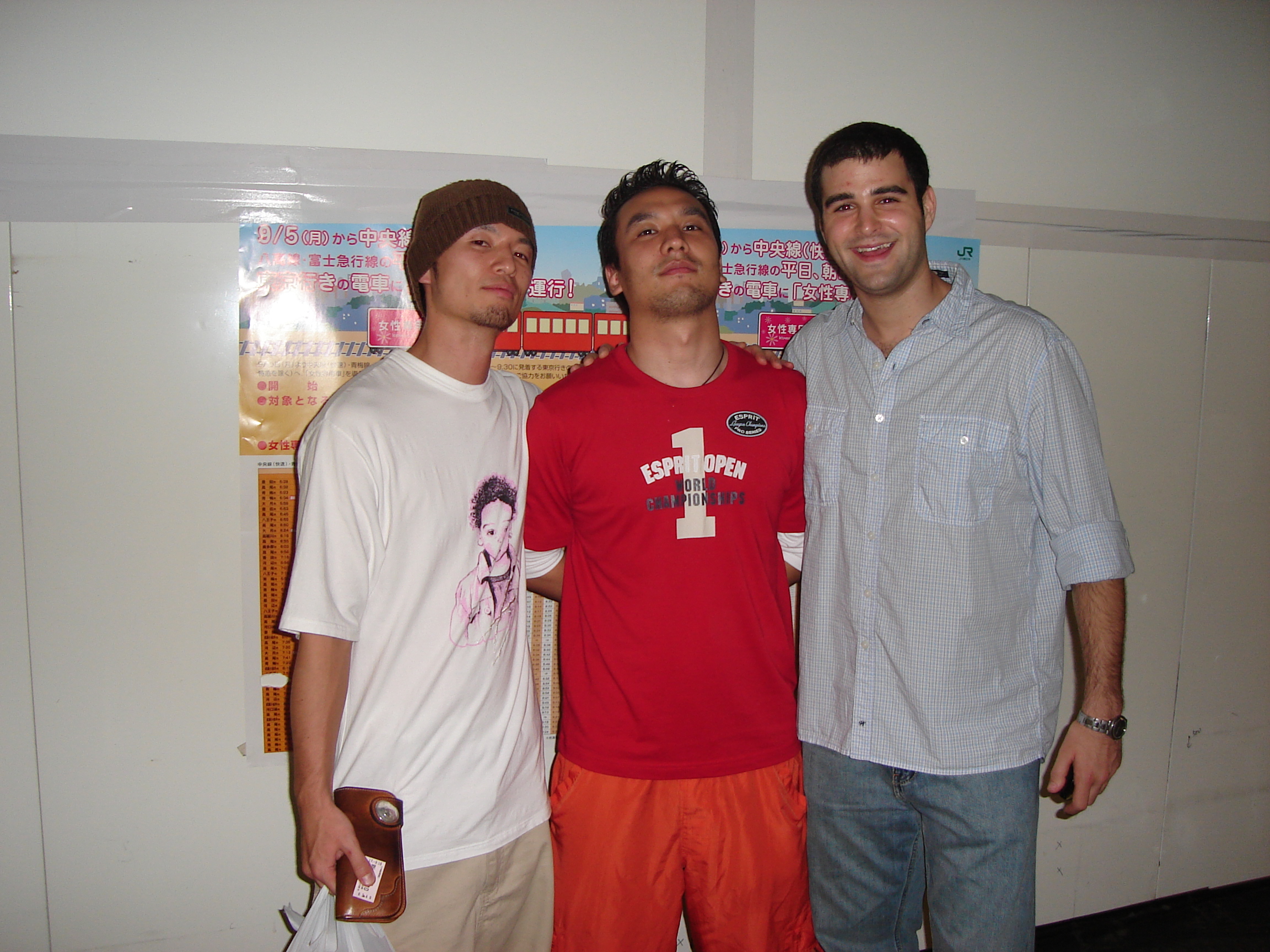 two japanese men and a caucasian man pose together