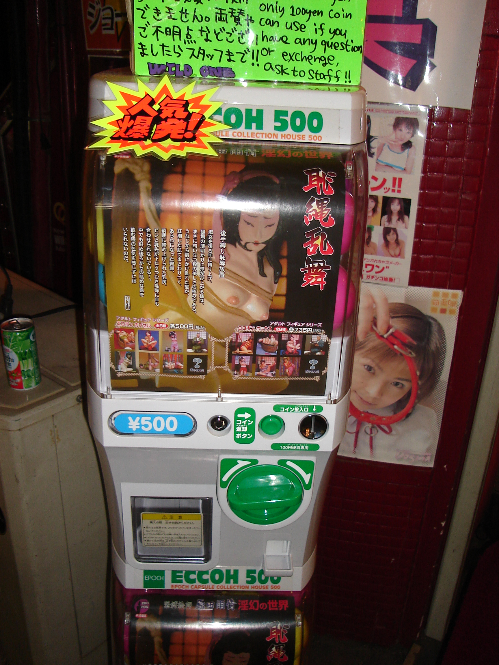a gachapon machine shows a photo of a japanese woman in bondage