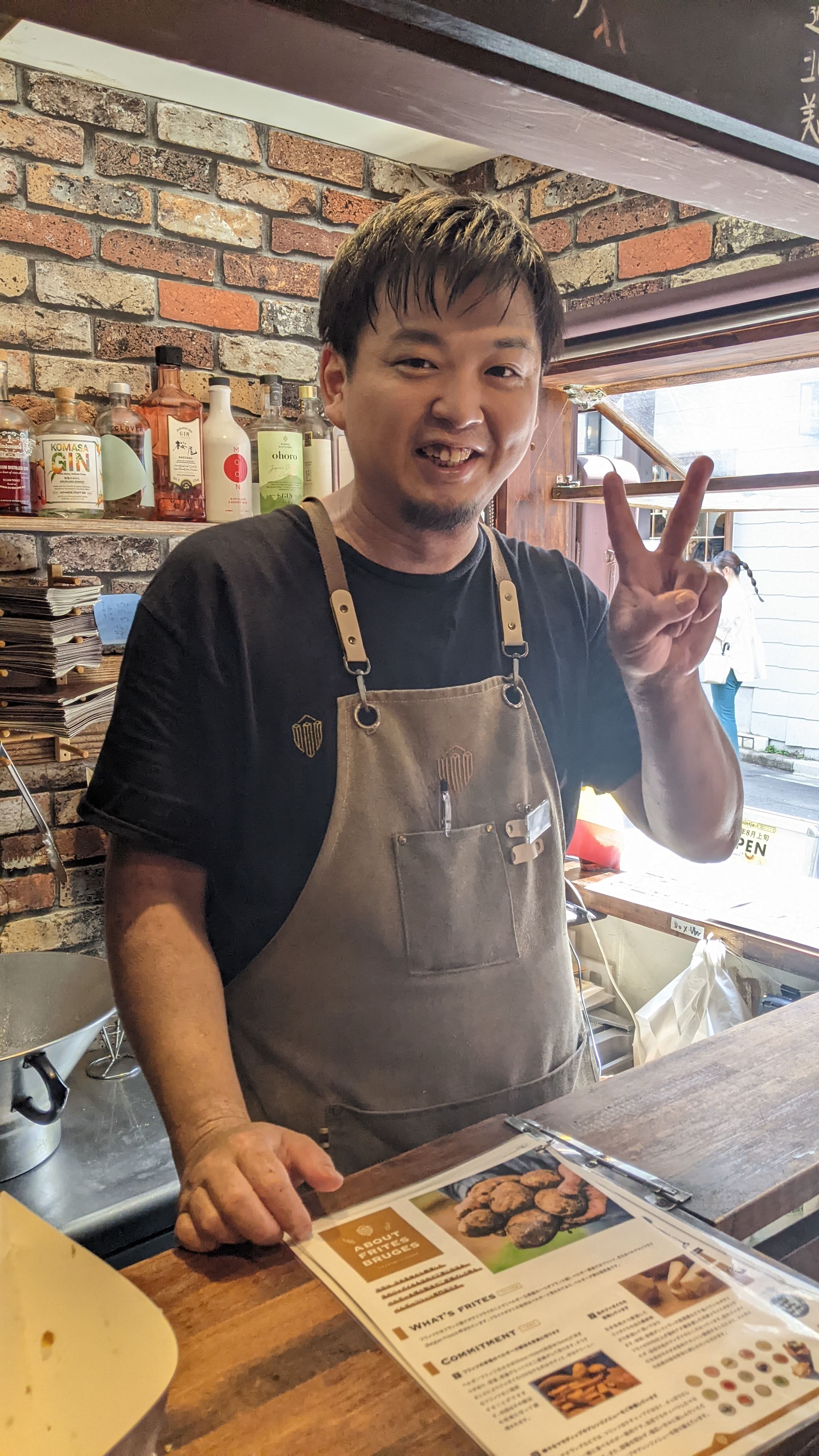 The owner smiling and showing a peace sign