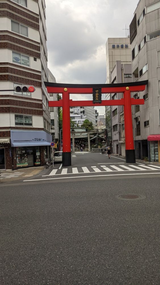 A vermillion torii gate at the entrace to a side street