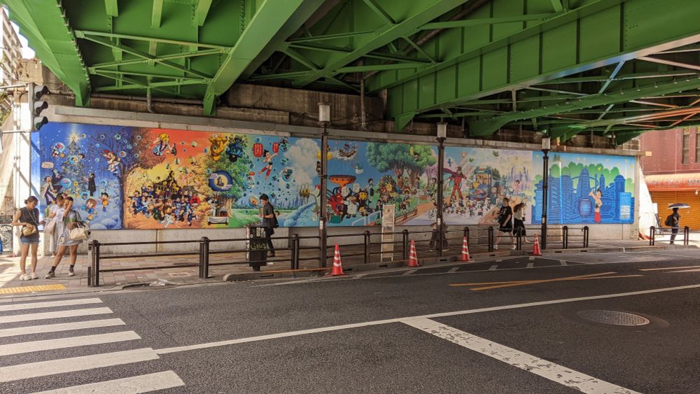 A colourful mural under a train bridge