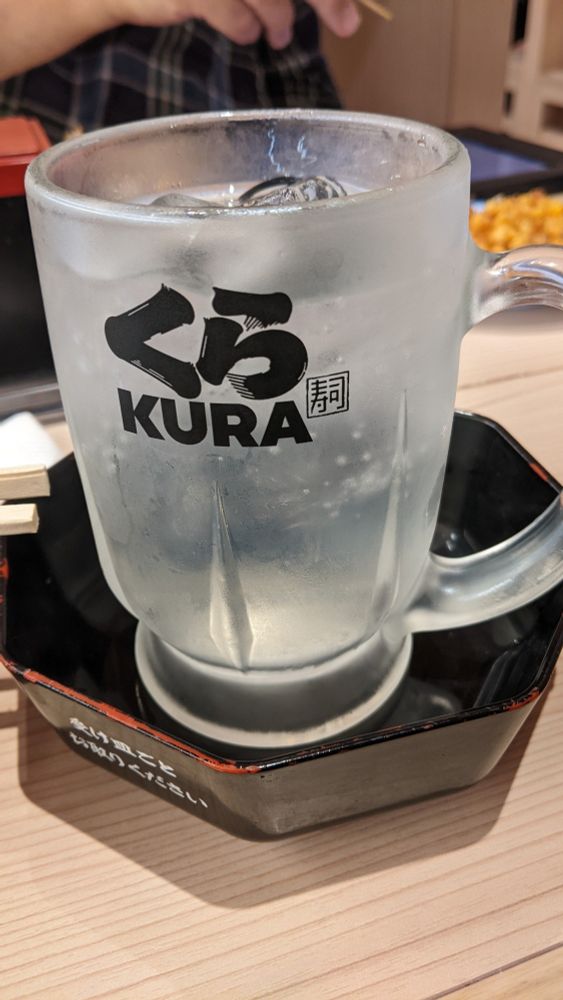 A glass mug of chu-hi with the Kura logo